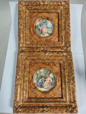 two framed paintings of a woman and a man in a garden