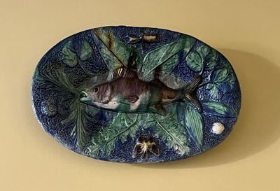 une assiette bleue et verte sur laquelle est représenté un poisson
