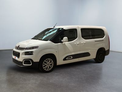 La camionnette blanche est garée dans une pièce au sol gris.