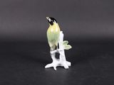 a small figurine of a bird perched on a tree branch