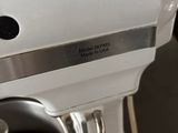 a close up of a white mixer with a metal bowl