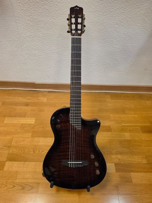 an acoustic guitar sitting on a hard wood floor in a room