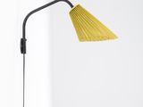 a yellow lamp on a white table next to a white wall