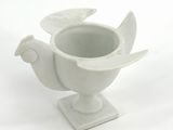 a white vase with a bird on top of it