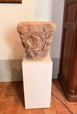 un vase en pierre posé sur un socle dans une pièce