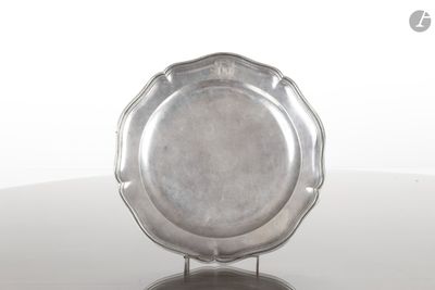 une assiette en argent posée sur un support, sur une table
