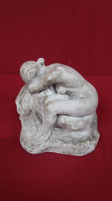 statue of a man hugging a woman on a red background