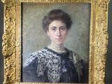 un tableau représentant une femme en robe noire, dans un cadre doré
