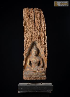 une image représentant une statue de Bouddha assis sur une souche d'arbre