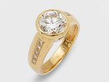 une bague en or sertie d'un diamant rond entouré de petits diamants