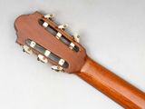 a close up of an acoustic guitar on a white surface