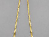 a gold necklace on a gray background