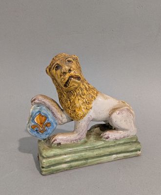 une figurine représentant un lion tenant un poisson dans la gueule