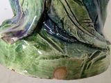 a ceramic statue of a frog sitting on a leaf