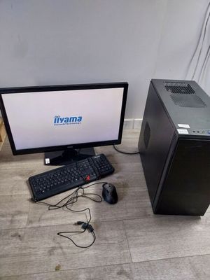 un ordinateur de bureau posé par terre à côté d'un clavier et d'une souris
