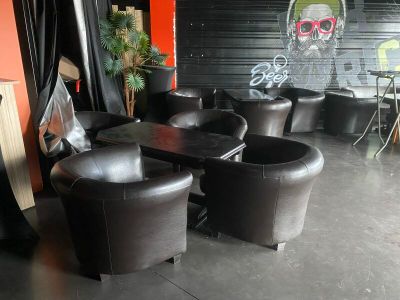 tables and chairs are lined up in a room with graffiti on the wall