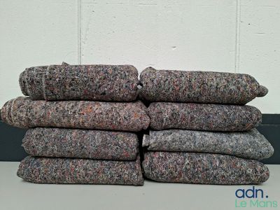 une pile de couvertures en laine grises et noires posée sur une table