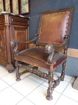 a brown leather chair sitting in front of a cabinet