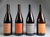 quatre bouteilles de vin sont alignées sur une table