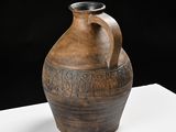 a large brown vase sitting on a white table