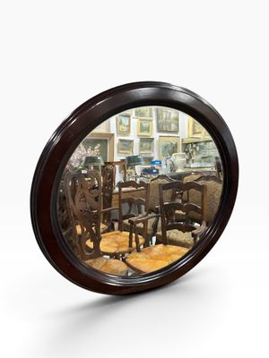 a round mirror with a reflection of a dining room in it