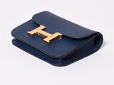 a blue leather wallet with a gold t on the front