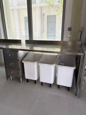 trois poubelles posées devant une fenêtre dans une cuisine