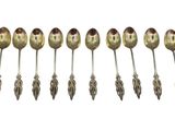 six spoons are lined up in a row on a white surface