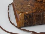 an old book with a leather strap on top of it
