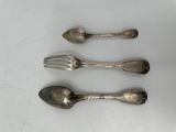 three silver spoons and a fork on a white surface
