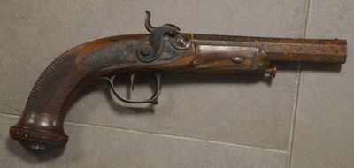 un vieux pistolet posé sur un sol carrelé