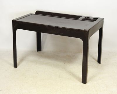 une petite table noire avec un plateau en verre, posée sur un sol blanc