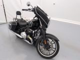 a black motorcycle parked in a room with a white wall