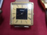 Trois montres différentes sont posées sur un tissu rouge, sur fond rouge.
