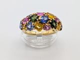 a ring with multi colored stones in it on a clear surface