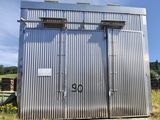 an image of a metal outhouse in the middle of a field