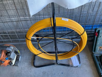 a yellow wire on a stand next to a yellow hose