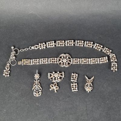 une photo d'un ensemble composé d'un collier, d'un bracelet et de boucles d'oreilles posé sur une table
