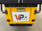 a yellow vehicle with a sign on the back of it