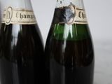 two bottles of champagne sitting next to each other on a table