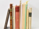 several books are stacked on top of each other on a white surface