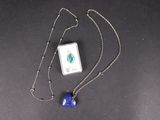 chaîne en argent avec un pendentif carré orné d'une perle de verre bleue