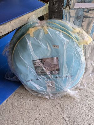 un sac de voyage emballé dans du plastique, posé par terre