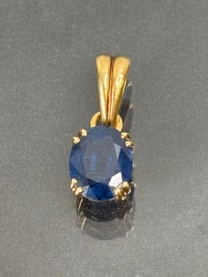 an image of a blue sapphire and diamond pendant on a silver surface