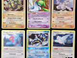 Plusieurs cartes Pokémon sont disposées sur une surface noire