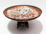 an orange and white bowl sitting on top of a wooden stand