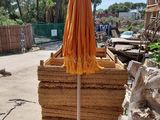 an orange umbrella that is on top of a pile of straw