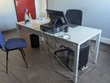 a desk with a computer and a chair in a room