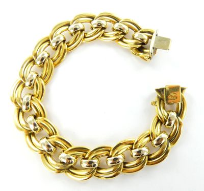 gros plan d'un bracelet en or sur fond blanc
