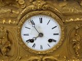 a gold clock with roman numerals on the face